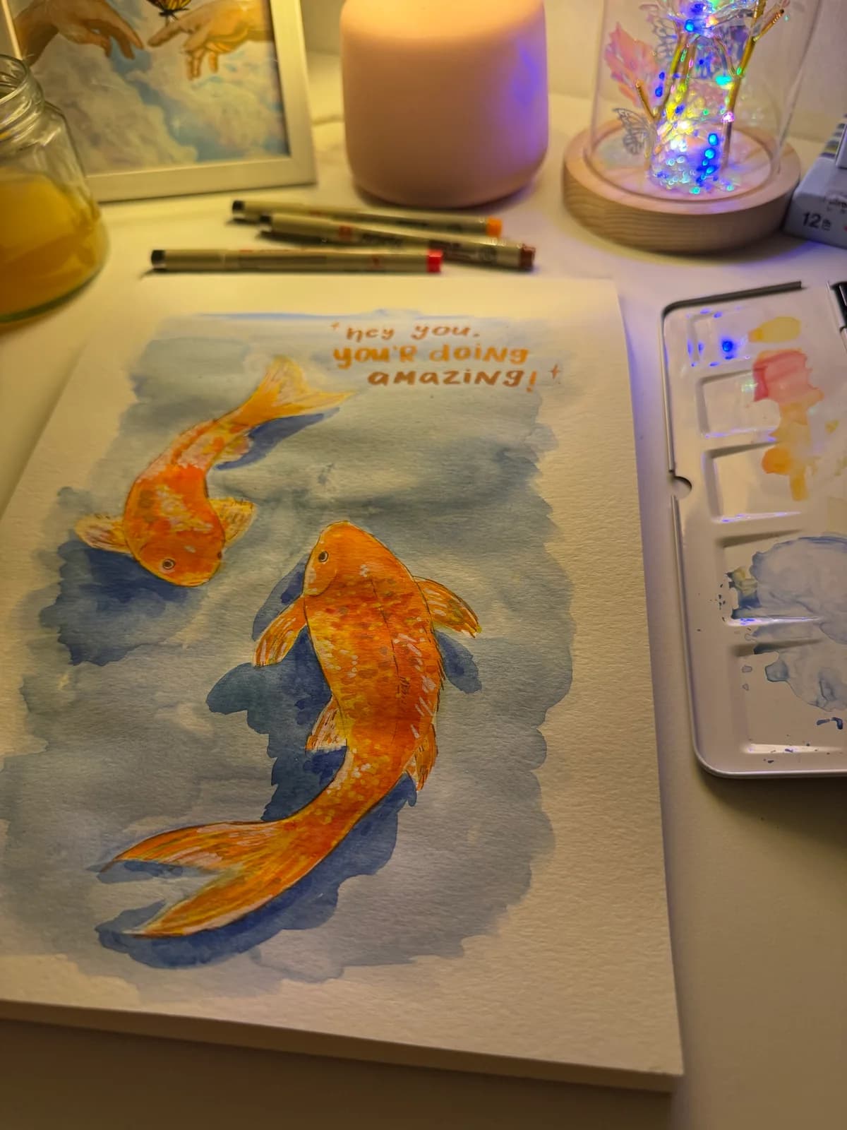 A koi fish watercolour in progress on Faiza's painting desk
